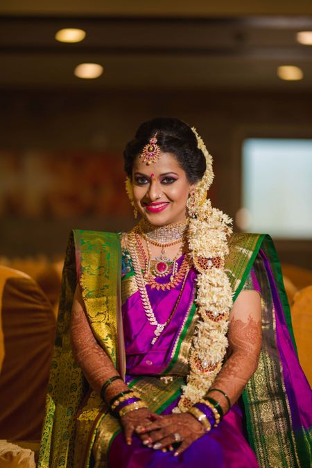 South Indian bride with floral braid hairstyle and kanjivaram saree