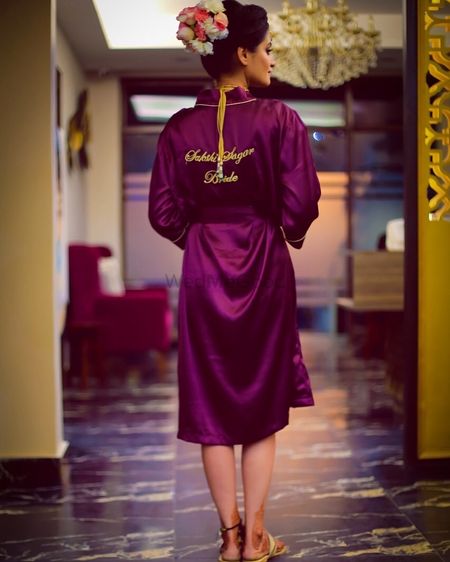 Photo of Getting ready shot with bride in wine coloured robe