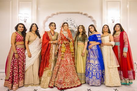 Photo of Bride with loads of bridesmaids in colourful outfits