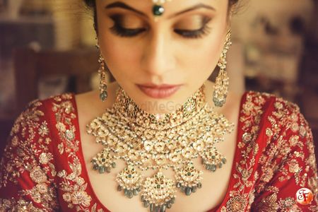 Contrast jewellery with red bridal lehenga 