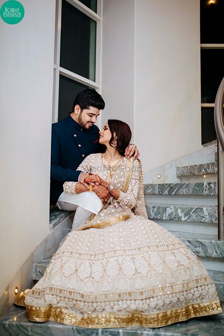 Stunning couple portrait with bride in white and gold lehenga
