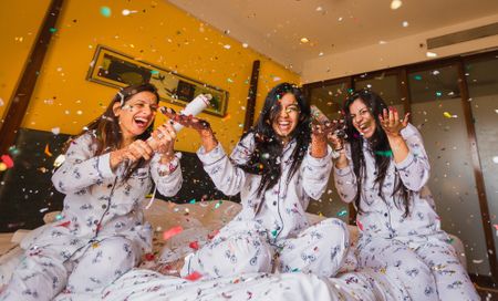 Bride and bridesmaids in matching pyjamas with confetti 