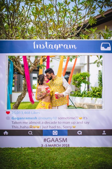 Couple kissing behind Instagram photobooth 