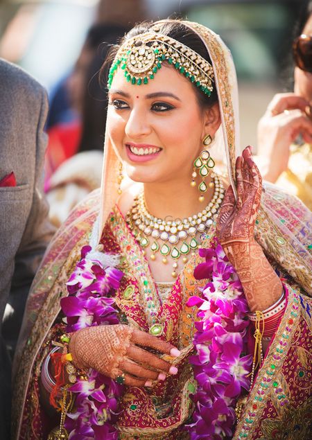 Happy bride shot in green Kundan jewellery 