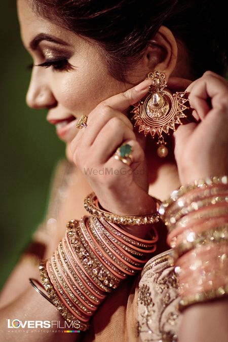 Bride wearing her earrings and bangles