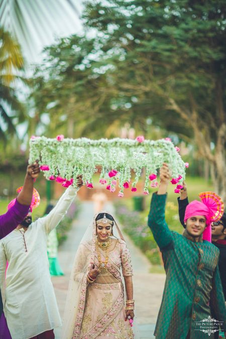 Bride entering under pretty phoolon ki chadar 