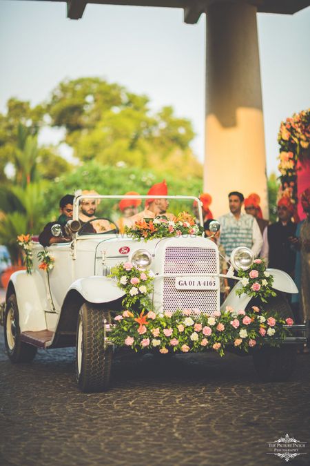 Groom entering his wedding in a vintage car