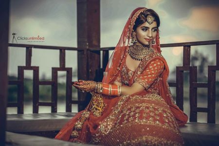 Bridal portrait of bride in red with green jewellery 