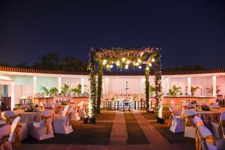 Photo of A floral mandap with seating arrangement around it.