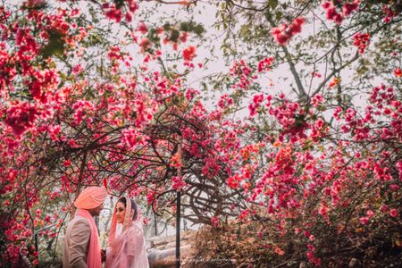 Couple shot against outdoor floral backdrop