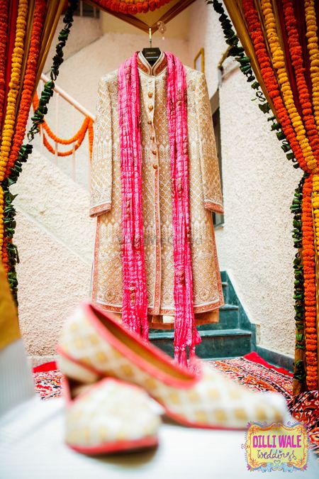 Groom sherwani on hanger with matching juttis 