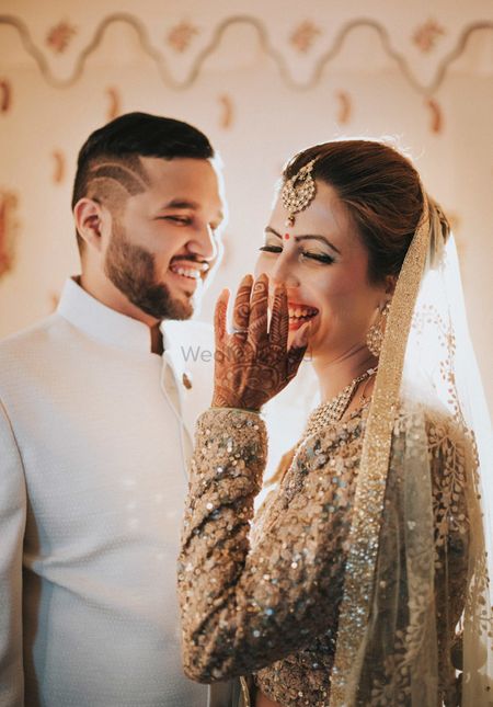 A bride laughs as her groom looks on