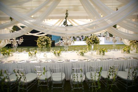 Photo of White drapes canopy with long table setting
