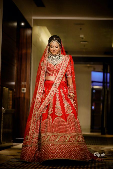 Photo of Beautiful north Indian bride looking stunning in red bridal lehenga .