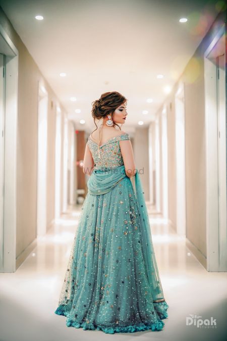 A stunning look of a bride in an off-shoulder blue lehenga. 