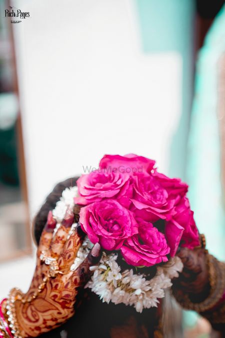 Bridal bun with pink lehenga using roses 