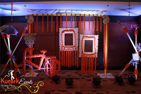 Pretty floral photobooth with hanging frames and bicycle for mehendi