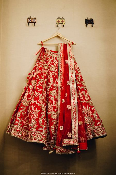 Photo of Red and gold bridal lehenga on hanger