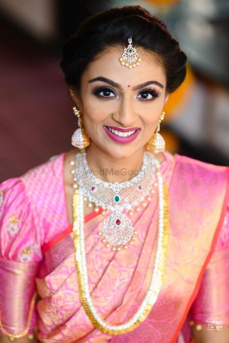 south indian bridal jewellery with layered necklaces and pink saree