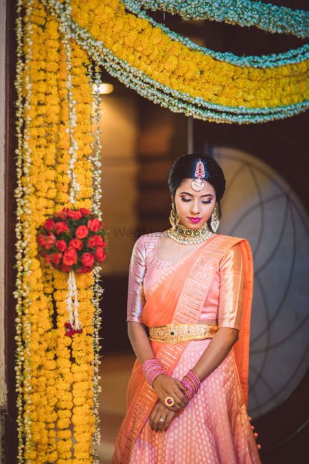south indian bride in orange kanjivaram and gold waistbelt 