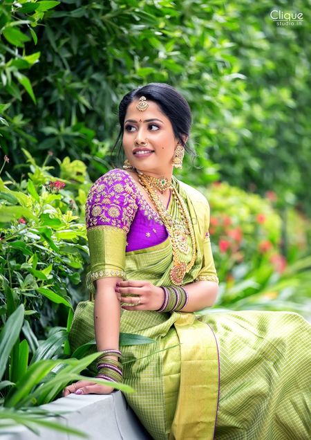 South Indian bride in a lime green saree with a  purple blouse.