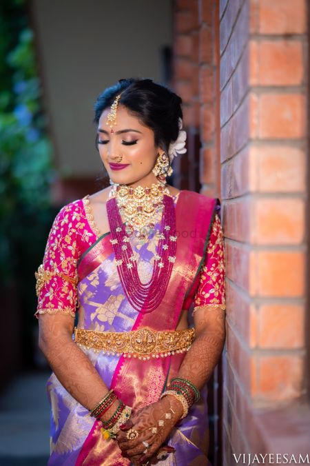 A south Indian bride dressed in a lavender and pink saree.