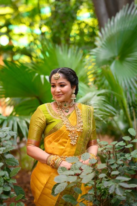 South Indian bride in a lime green and yellow saree.