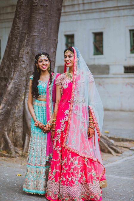Bride with sister in bright lehengas 