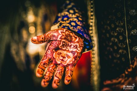 Groom wearing mehendi with brides name and a panda