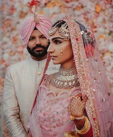 Couple portrait with bride in light pink lehenga and pretty jewellery
