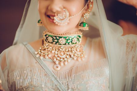 Indian bride wearing gold and green emerald choker for wedding 
