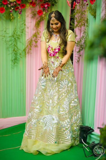 Bride in light green lehenga and floral jewellery 