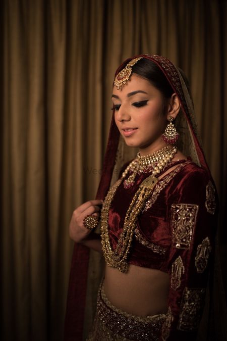 Photo of A bride in maroon and gold