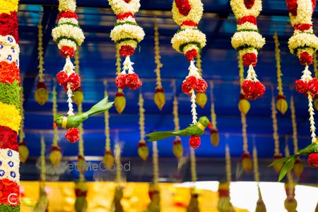 Cute hanging parrot decor with red and white flowers for south Indian wedding 