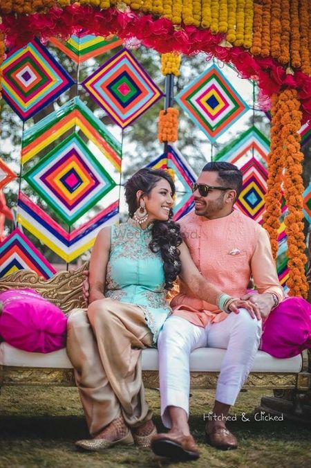 Photo of Mehendi couple portrait with colourful backdrop