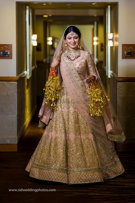 Bride twirls in pink and gold lehenga
