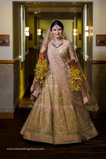 Bride twirls in pink and gold lehenga