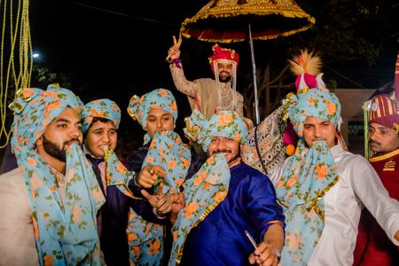 Photo of Matching groomsmen with floral safa in baraat
