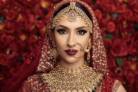 A bride in red lehenga and heavy jewellery