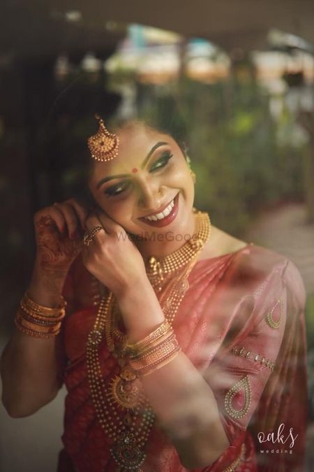 Photo of South Indian bride wearing jewellery getting ready shot