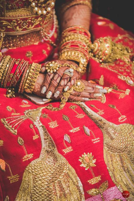 Bridal hands with unique peacock motif lehenga