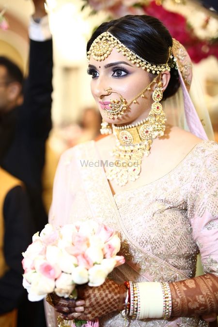 Photo of Bride in pastel lehenga choker and white Chura
