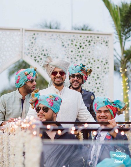 Groom entering with groomsmen wearing matching floral safas 