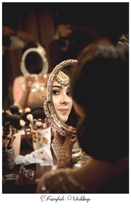 Photo of bride looking in the mirror