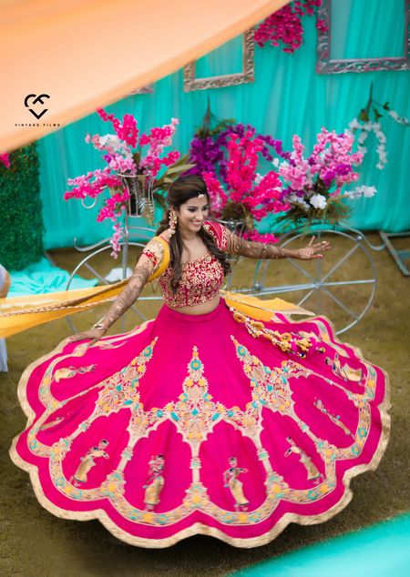 A bride in pink lehenga twirls on her mehendi day