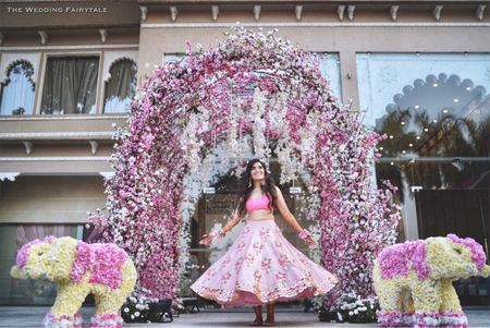 Twirling bride against pink mehendi backdrop 