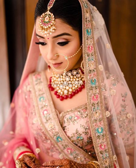 Bride in pink lehenga with red jewellery