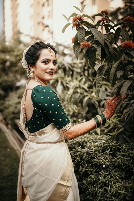 South Indian bridal look with green blouse and off white saree 