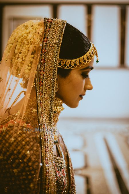 Bridal bun with florals and dupatta over it 