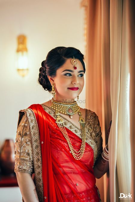Photo of Red and Gold Lehenga Bride with Gold Maangtikka